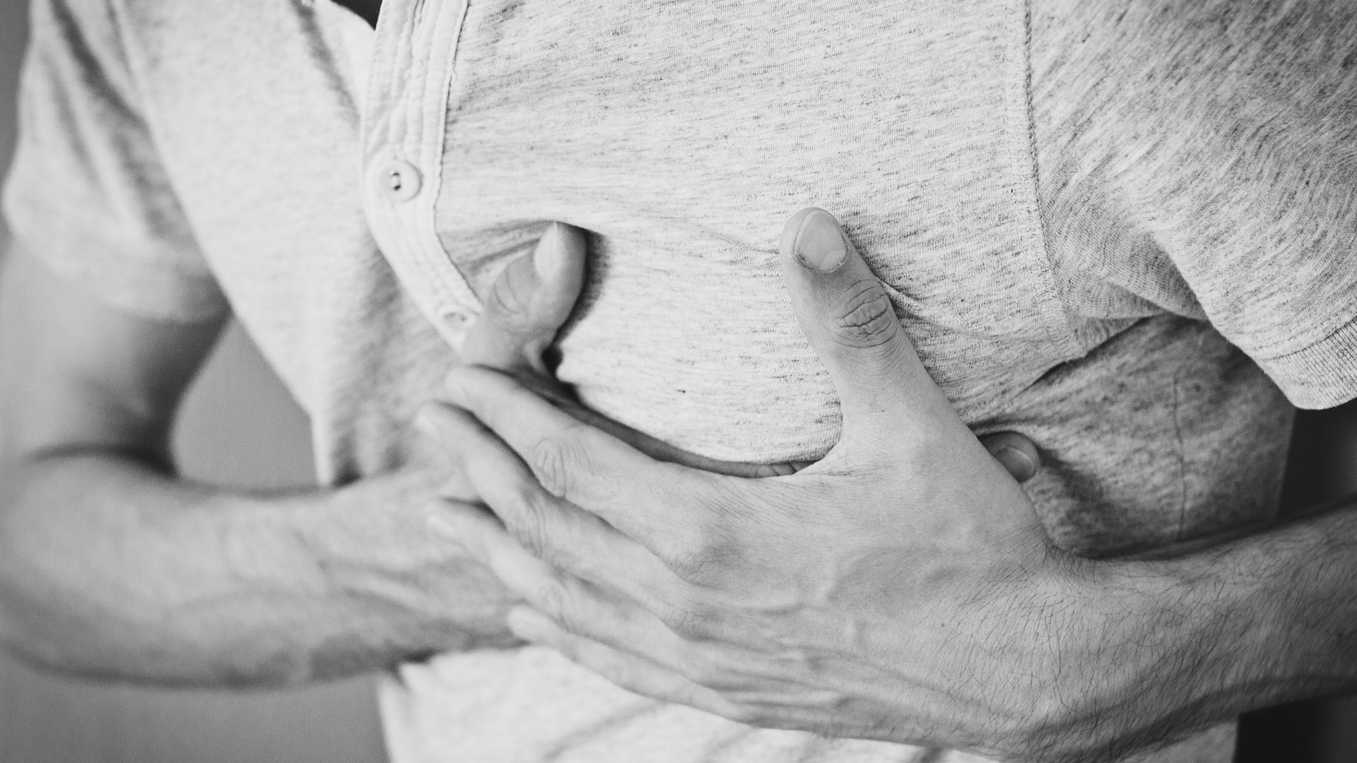 Persona con entrambe le mani appoggiate sul petto, gesto tipico di chi avverte il cardiopalmo